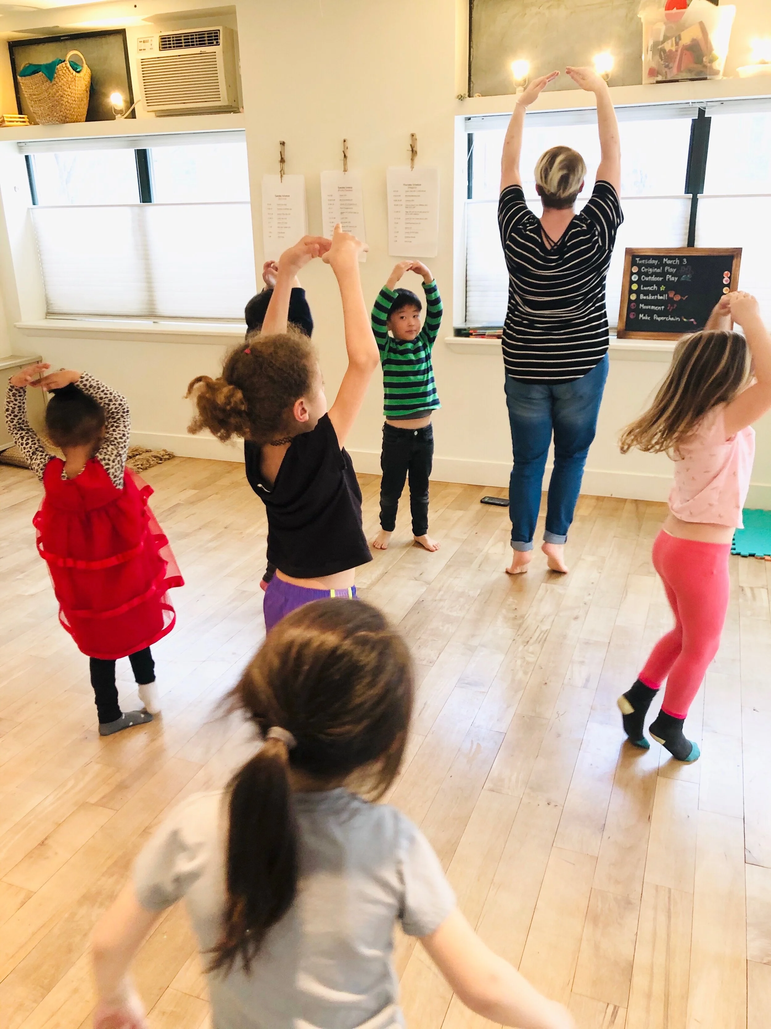 Performer showing alternative school children how to twirl and dance at Pono