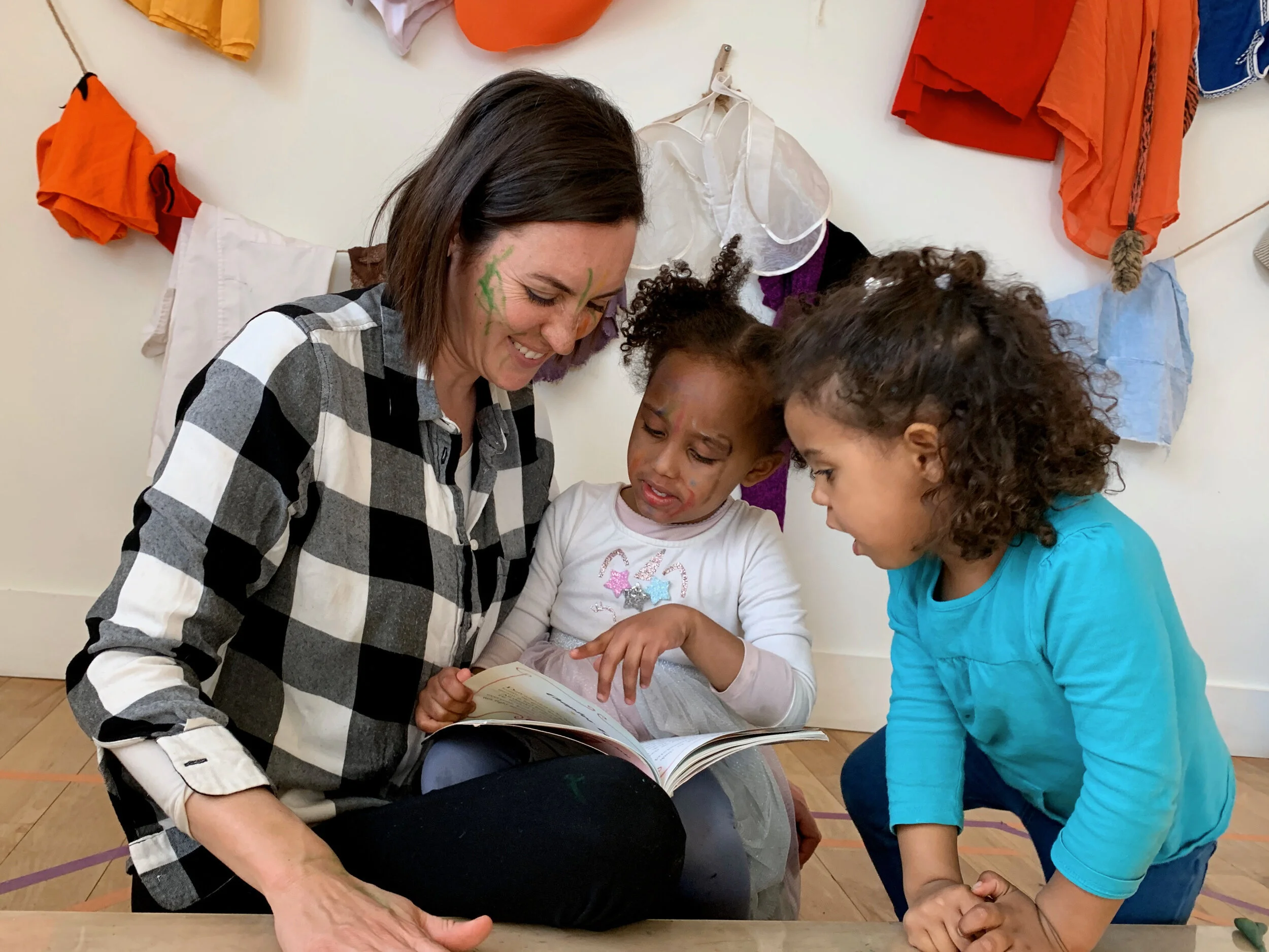 Democratic alternative teacher reading books with kids and young children at Pono