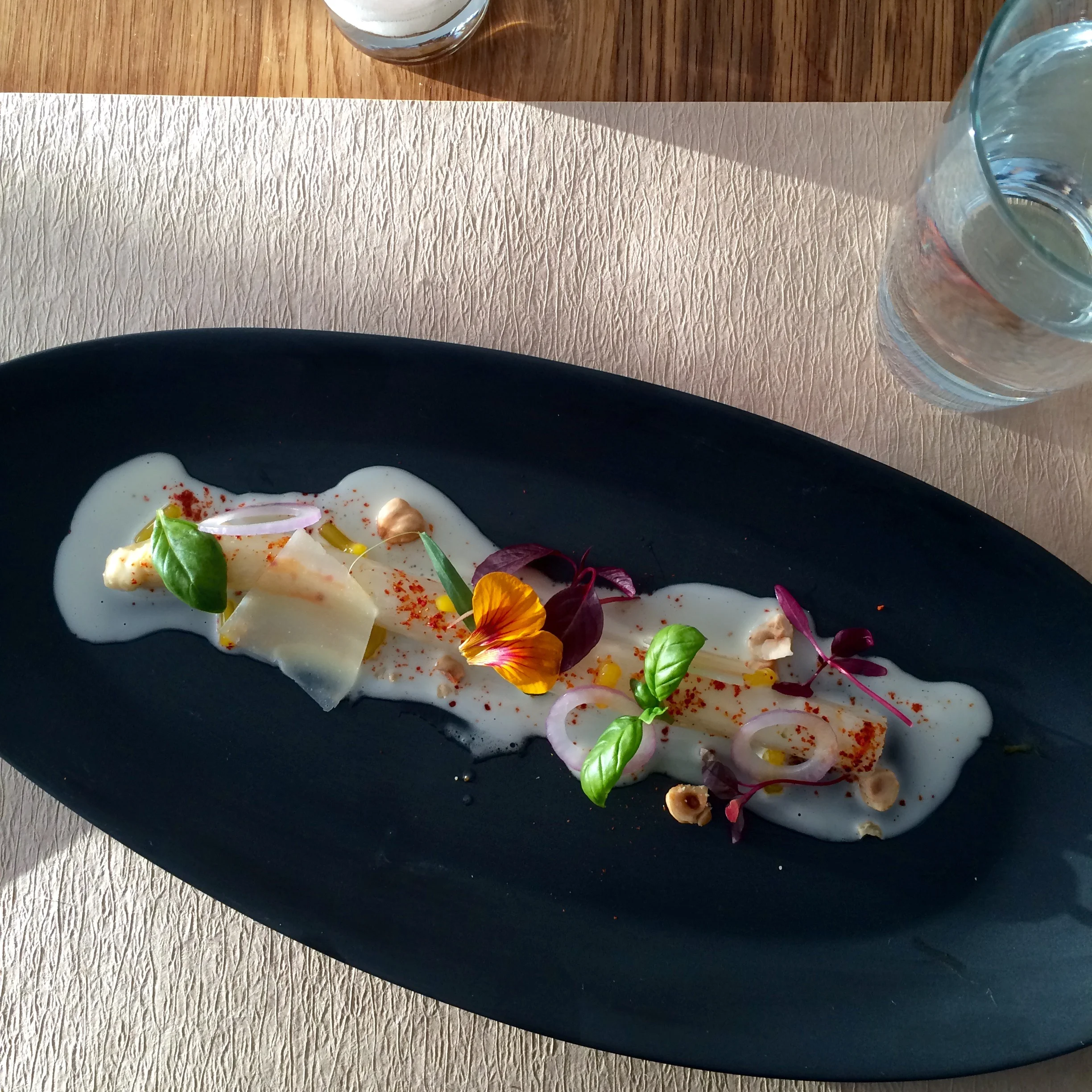 White asparagus, parmesan cheese, basil, edible flowers, and hazelnuts