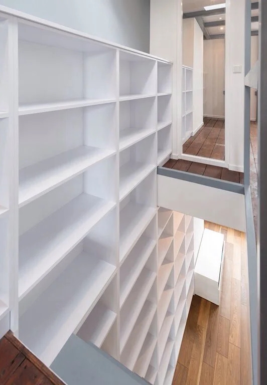 Two story high library extending from lower floor through stair opening to both bedrooms. Fabrication and installation by www.zero-lab.com