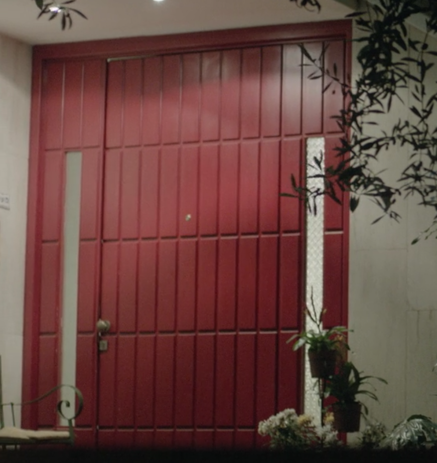 Quite massive residential entrance door. Effect of size enhanced by raised panels used on both doors and sidelights. Image borrowed from the movie "Hostages".