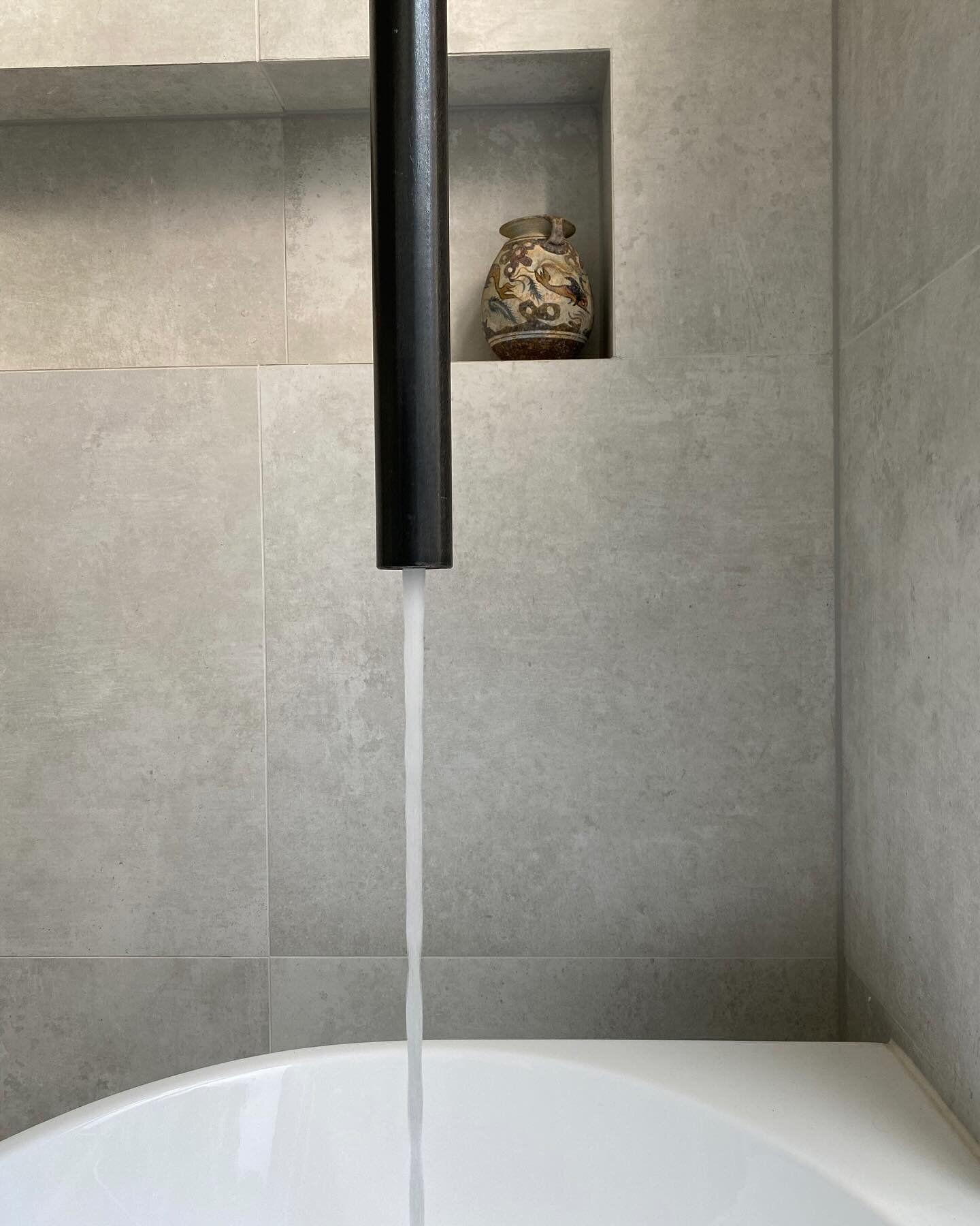 A standout feature in the bathroom of recently completed redesign of a luxury apartment is the custom-designed ceiling-mounted bathtub faucet. This bespoke element not only showcases the commitment to unique and personalized design but also contribut