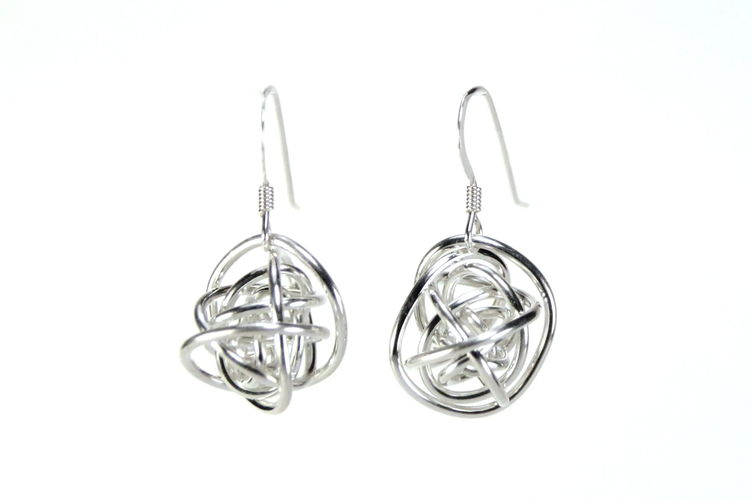 Earrings are sterling silver wire wrapped loosely into a ball. The silver wire is shiny and smooth. Earring wires are bright silver french hooks.