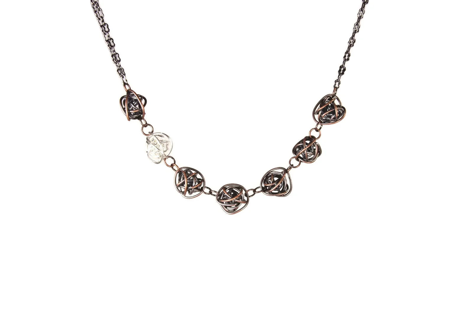 Necklace is loosely wrapped wire balls attached horizontally and finished with antiqued copper peanut chain. 6 balls are antiqued copper, 1 is bright silver. The silver ball is second from the end.