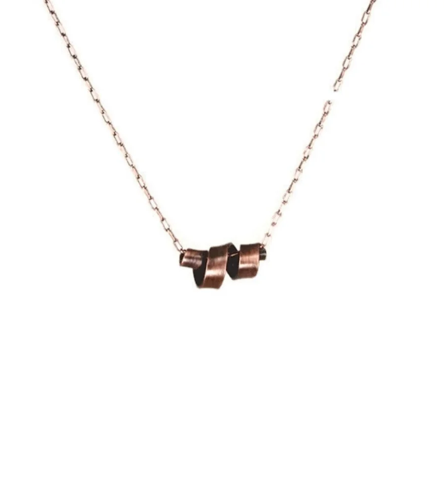 Necklace is a strip of copper twisted into a corkscrew curl shape around an antique copper chain. The copper is darkened to brownish-black with hints of copper showing through a brushed finish.
