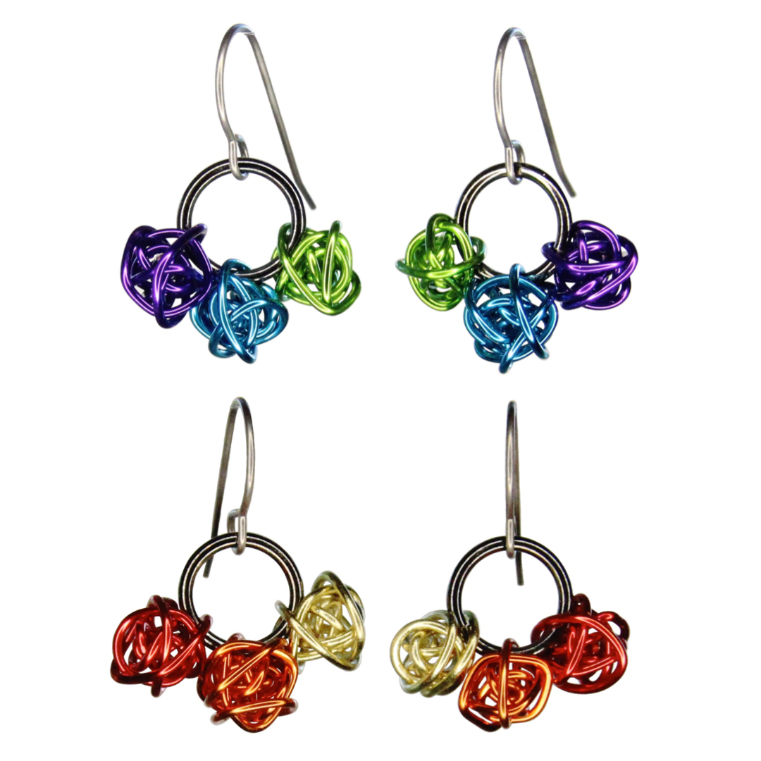 Each earring has 3 loosely wrapped small colorful shiny wire balls. The balls are strung on the bottom of a shiny black metal ring. Image shows two color options – cool and warm.