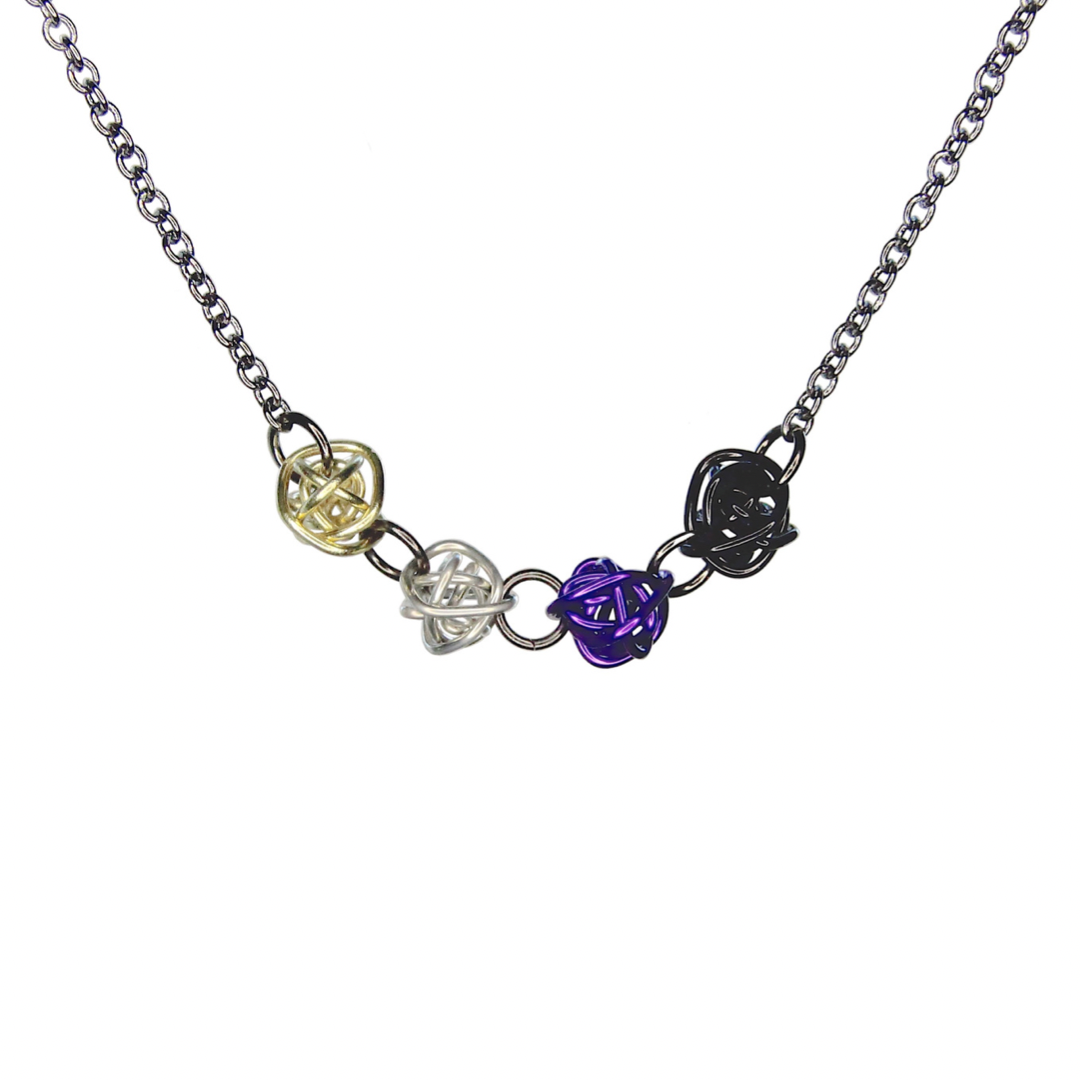 Necklace has 4 colorful loosely wrapped wire balls attached together horizontally by jump rings in order of the nonbinary pride flag - yellow, silver, purple, black. The wire is shiny and smooth.