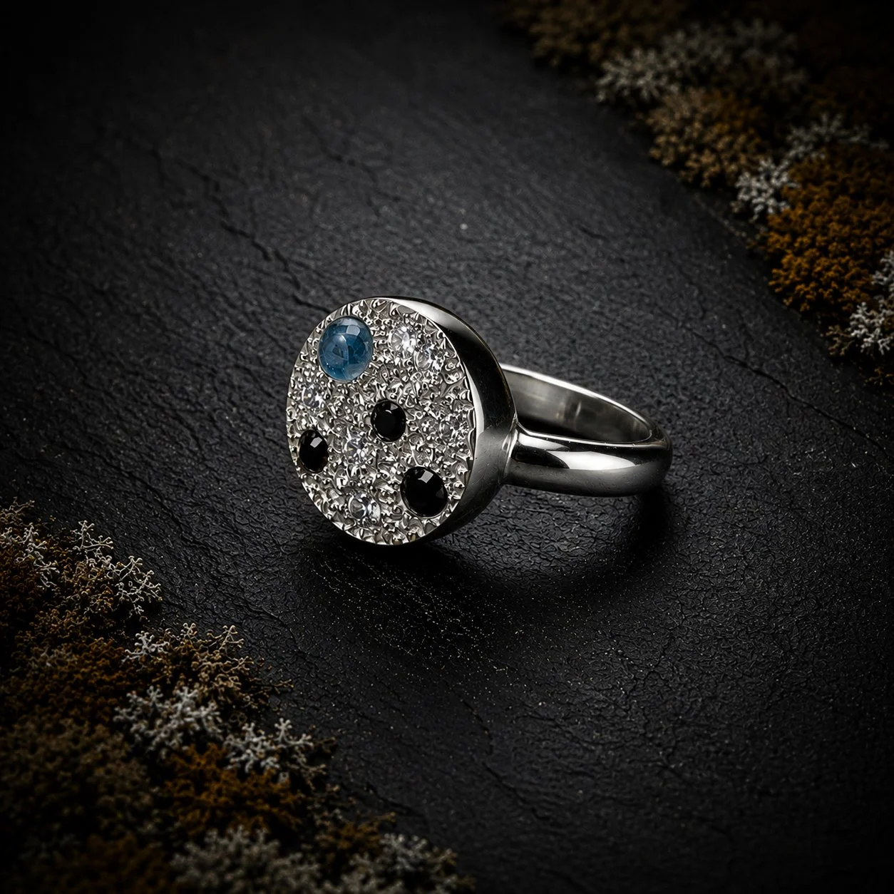 Side view of handmade Enchanted Lichen Ring showing its raised sculptural silver setting