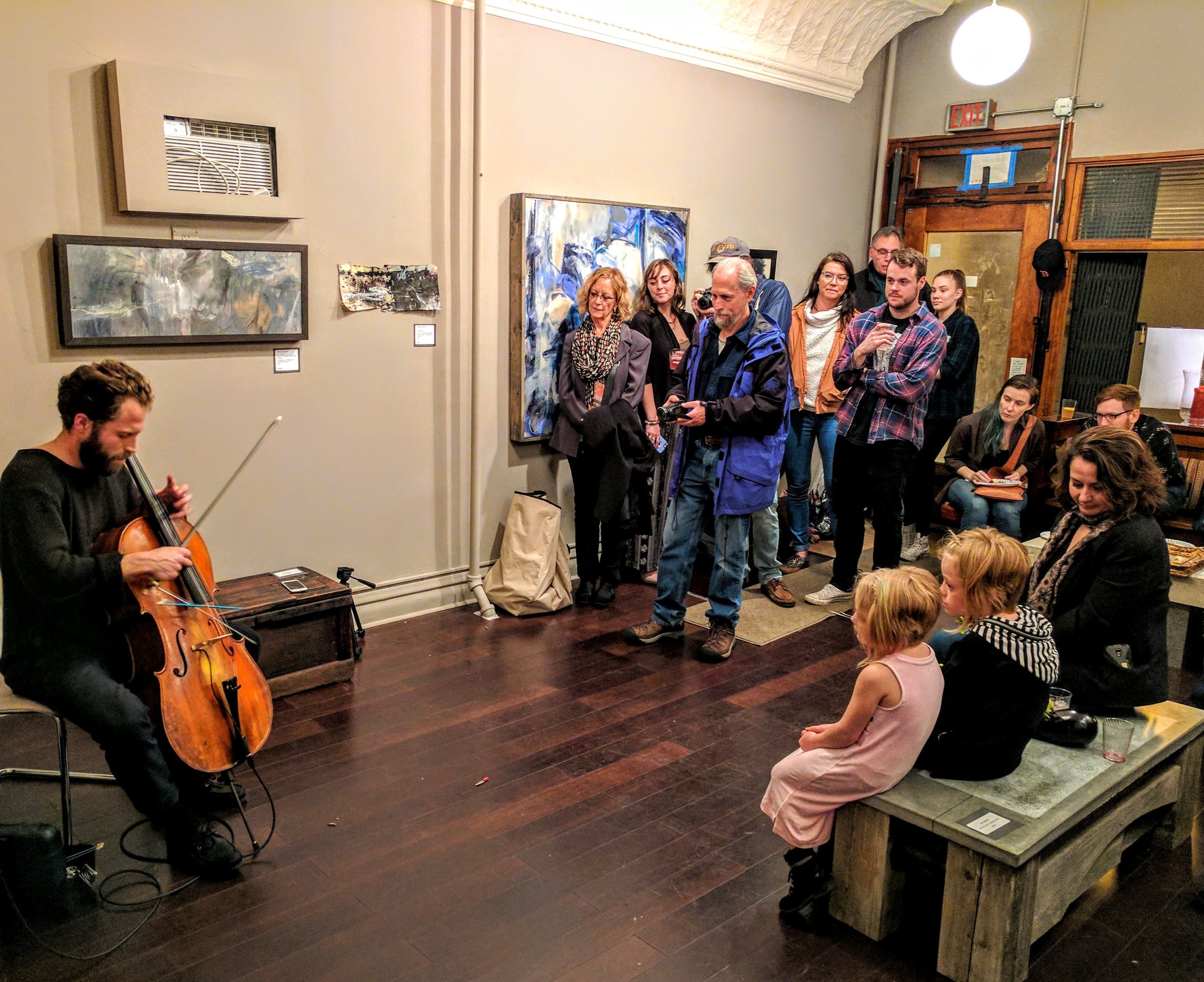 Teddy Rankin-Parker playing cello for a packed gallery during the Abstract Workshorses show.