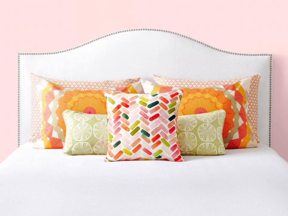 warm coloured pillows on a white bed.jpeg