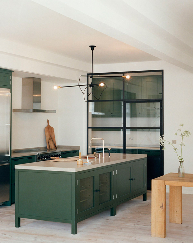 12-green-kitchens-long-island-with-dark-green-cabinets-and-cutting-boards-against-wall.jpg