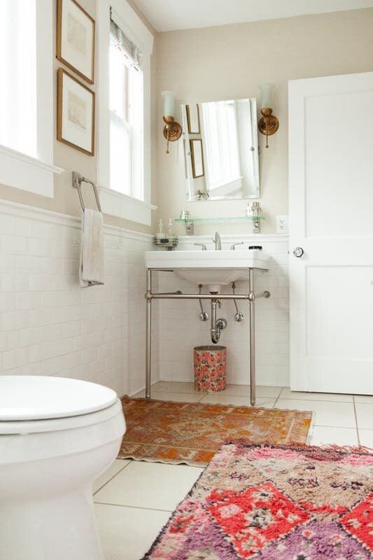 No one will notice an ugly bathroom if you add an eye catching rug... or two