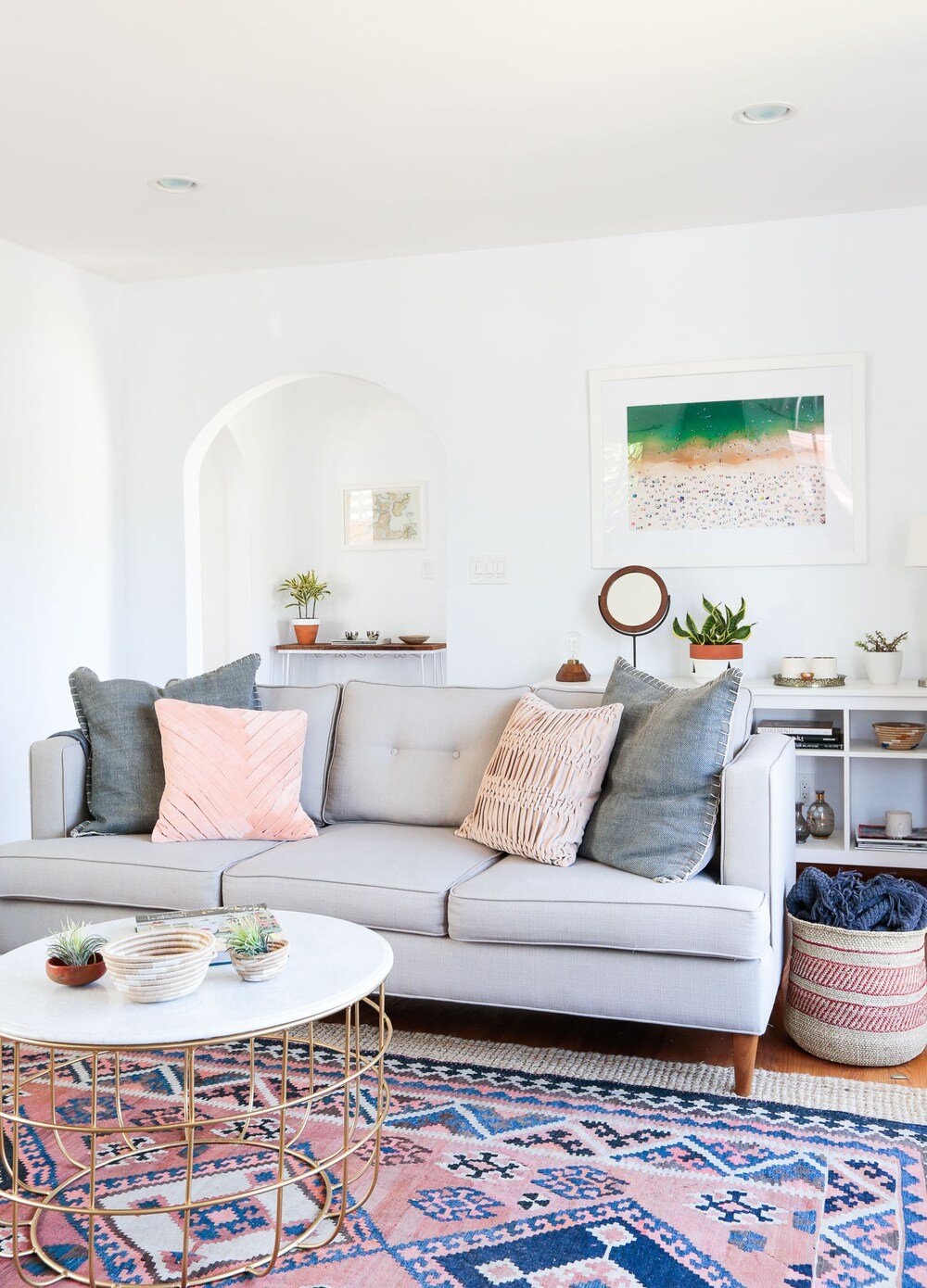 Grey-sofa-with-pillows-and-pink-patterned-rug.jpg