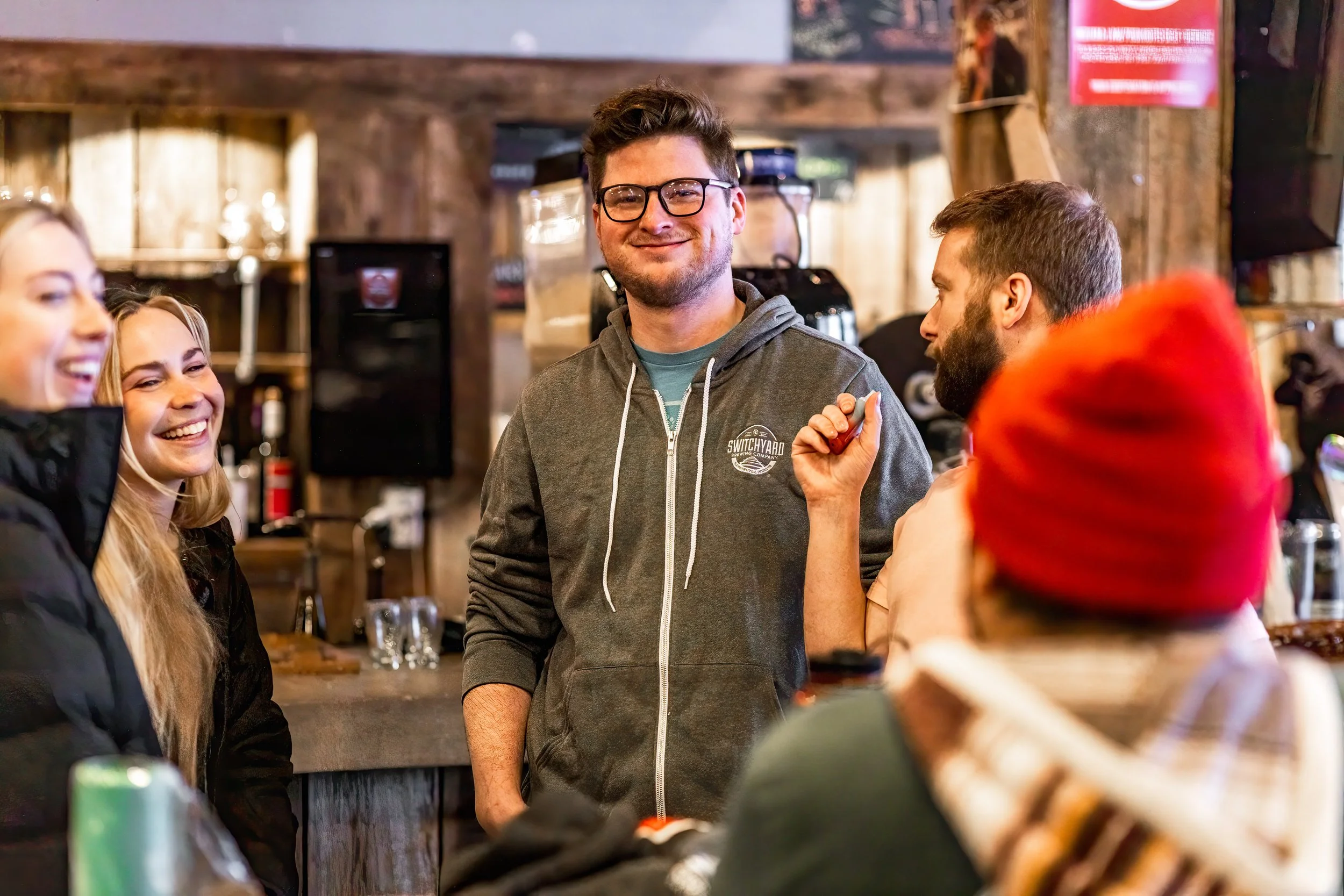 people gather at a brewery smiling and chatting