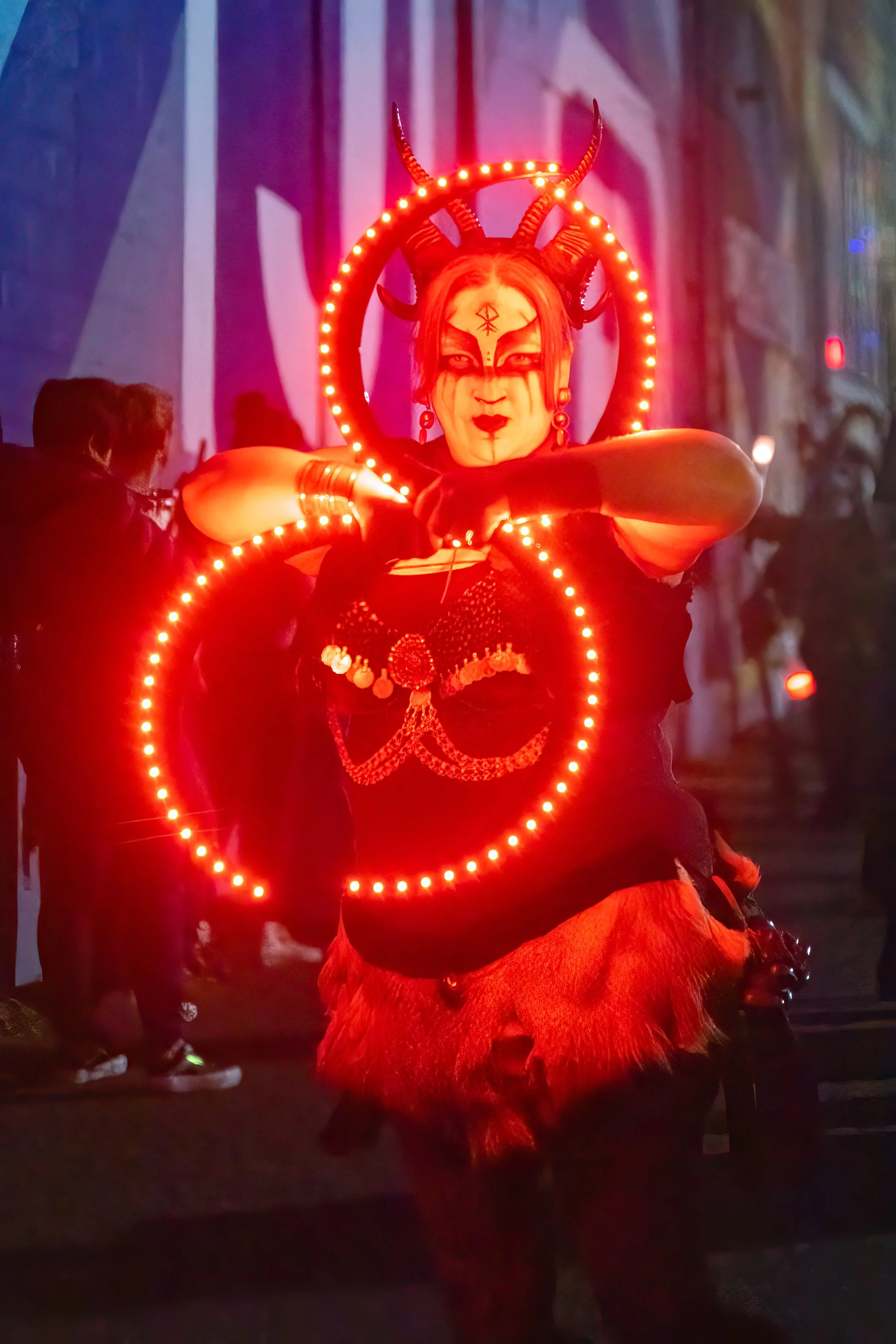 woman performs in costume with red lighted wands