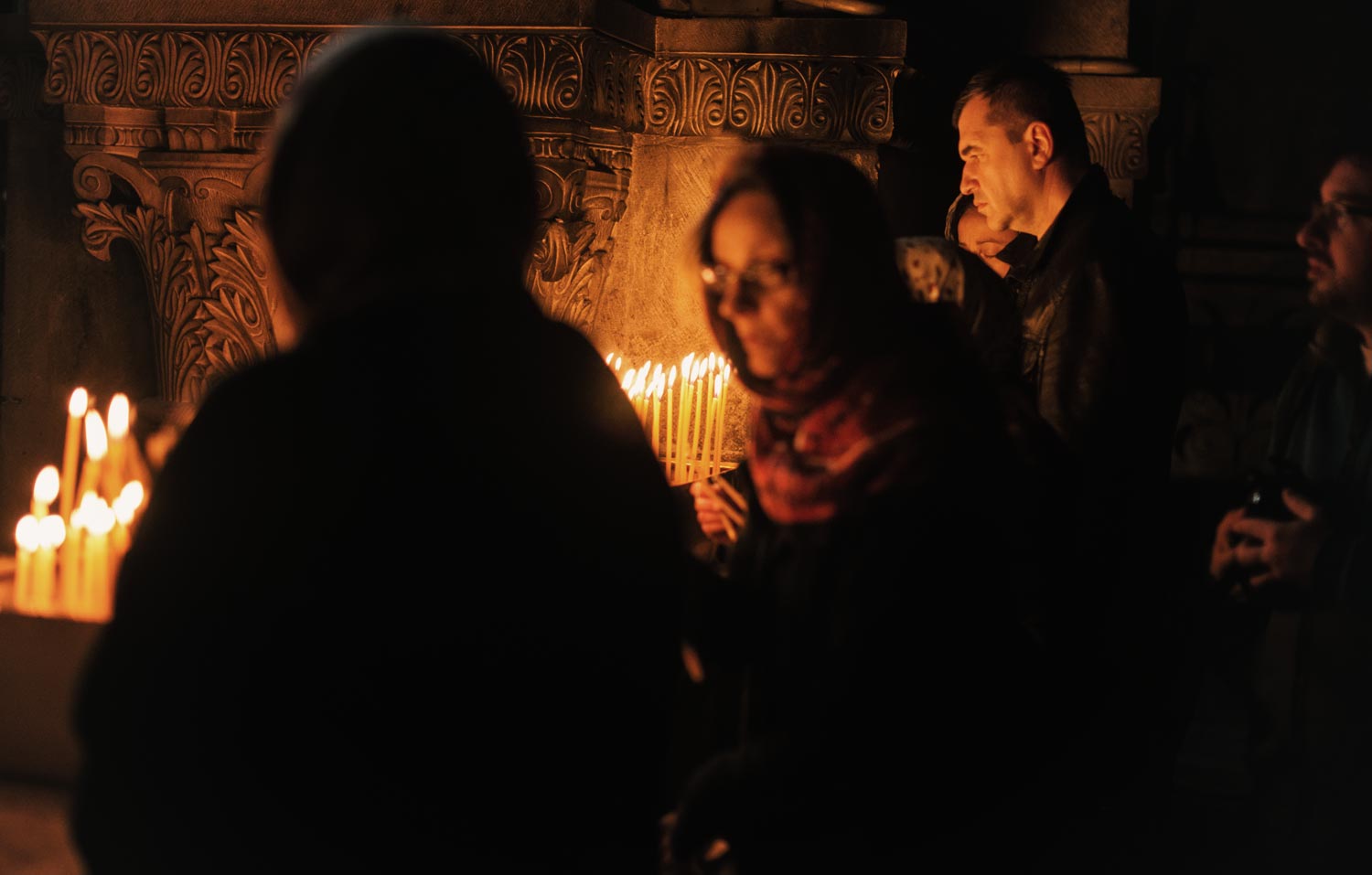  People lighting candles at the Church of the Holy Sepulcher. 