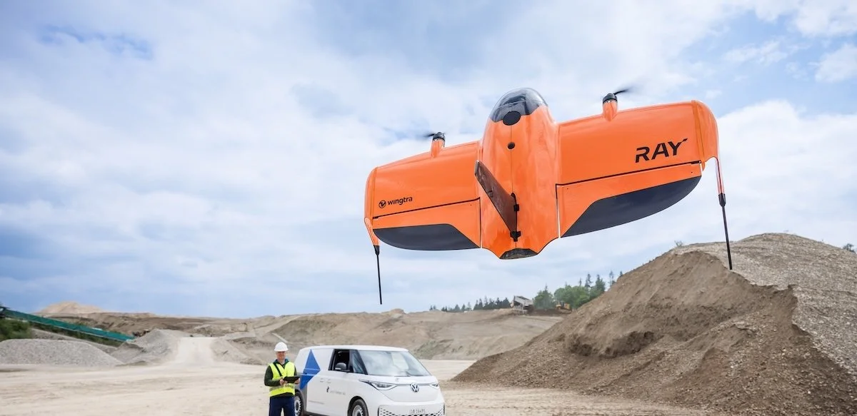 WingtraRAY fixed-wing VTOL drone flying over construction site
