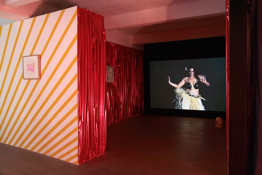 Video : Natacha LESUEUR. Upa Upa, 2012. Video HD. 16'10''. Edition de 5. Courtesy de l'artiste John M ARMLEDER. Untitled, 2001. Oeuvre murale, papier rouge métallisé \ Wallpainting. Dimensions variables . Dimensions variables. Courtesy de l'artiste et Galerie Caratsch, Zürich