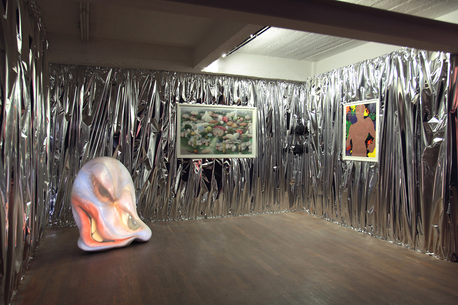 Gauche \ Left : Tony OURSLER. Thaw, 2003. Fibre de verre, projection video, haut-parleurs \ Fiberglass, video projection, speakers . 119,5 x 114,5 cm. 11'12''. Performer Tracy Leipold. Courtesy de l'artiste et Galerie JGM., Paris Arrière plan \ Background : John M ARMLEDER. Untitled, 2001. Oeuvre murale, papier argent métallisé \ Wallpiece, silver metallic foil . Dimensions variables. Courtesy de l'artiste et Galerie Caratsch, Zürich