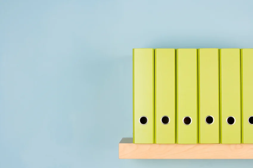 green ringbinders neatly arranged on shelf.jpg