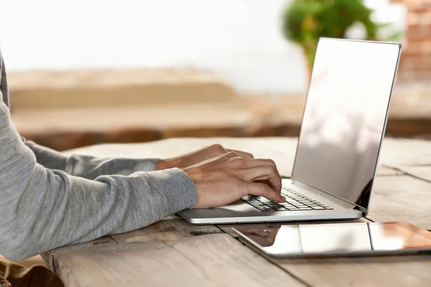 man's hands on laptop keyboard at table.jpg
