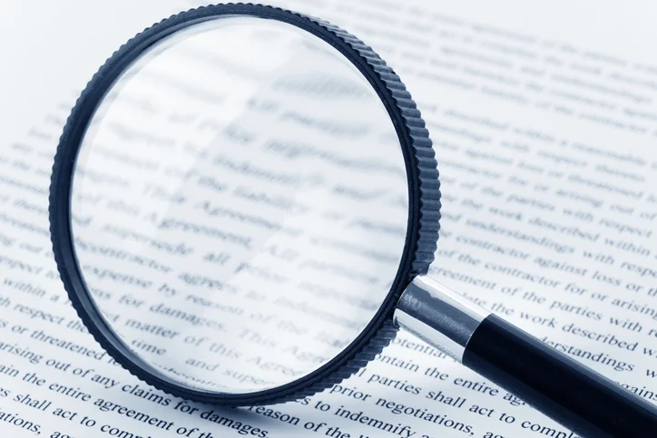 Black-magnifying-glass-over-page-of-book.jpg