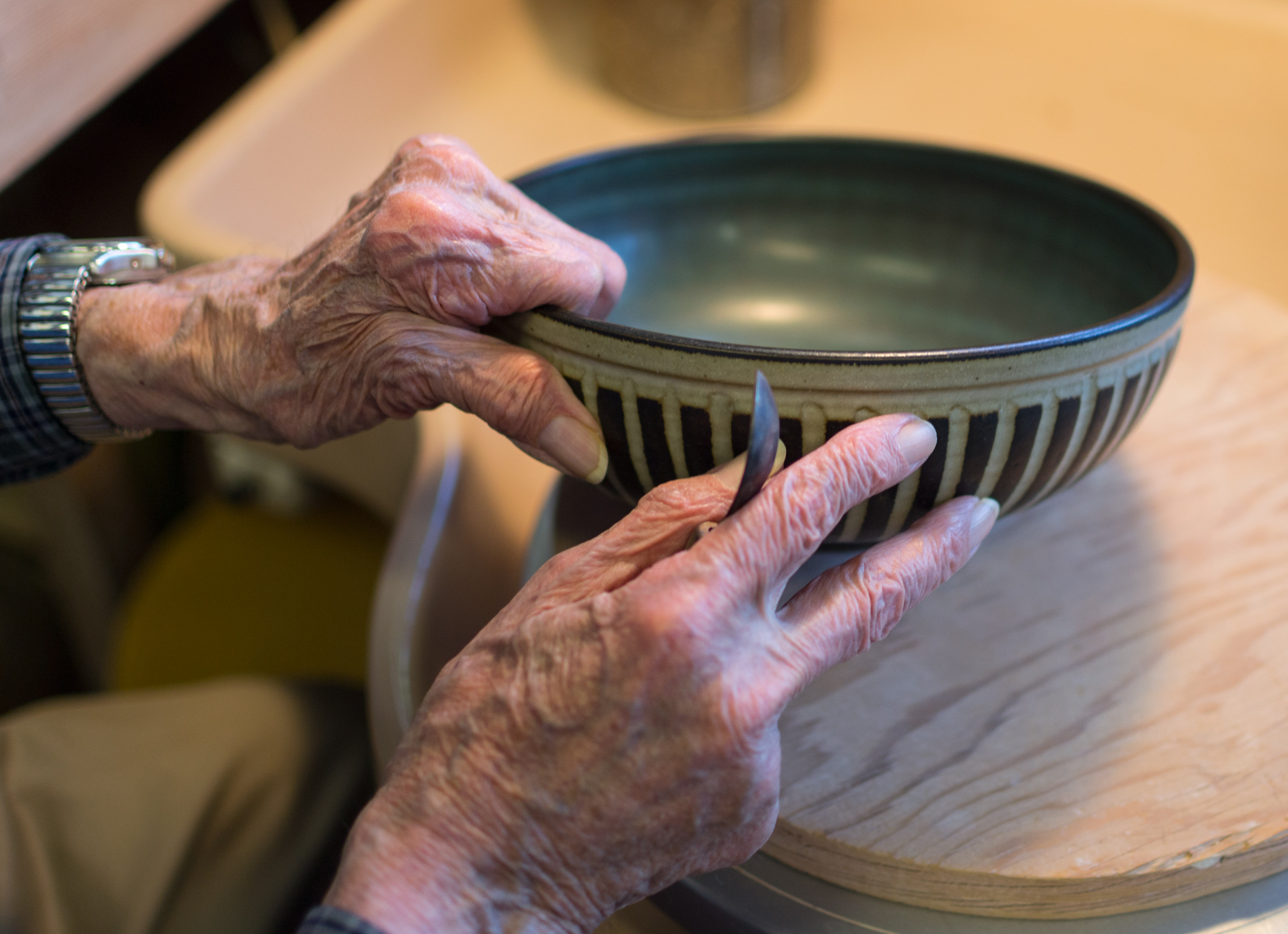 Harrison McIntosh, though mostly blind, explains from memory and touch how a similar clay-lifting tool gives his art texture. McIntosh’s technique included using old dentist’s tools that he modified himself and various paintbrushes from around the world.