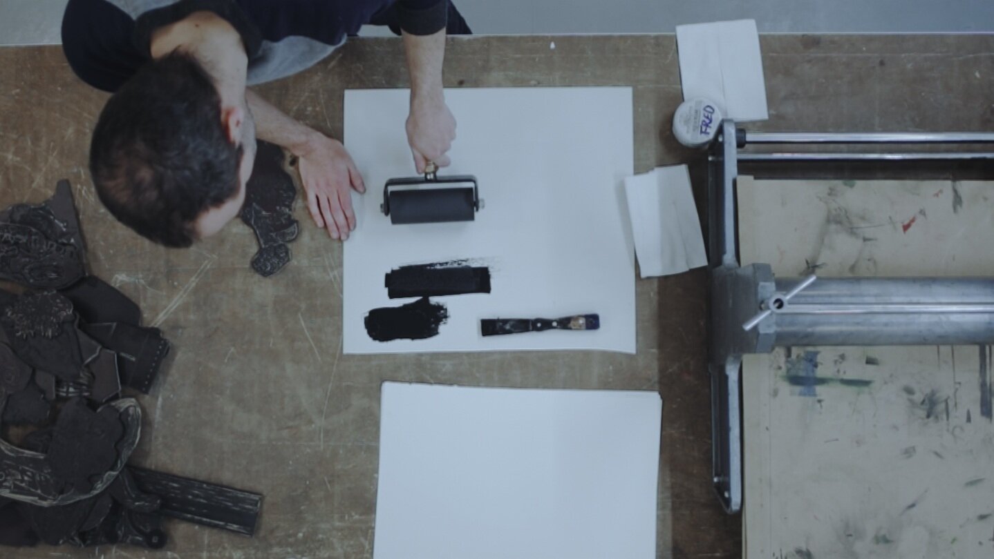 Applying ink on woodcut plate for printmaking in Mécaniques Discursives by Fred Penelle and Yannick Jacquet.jpg