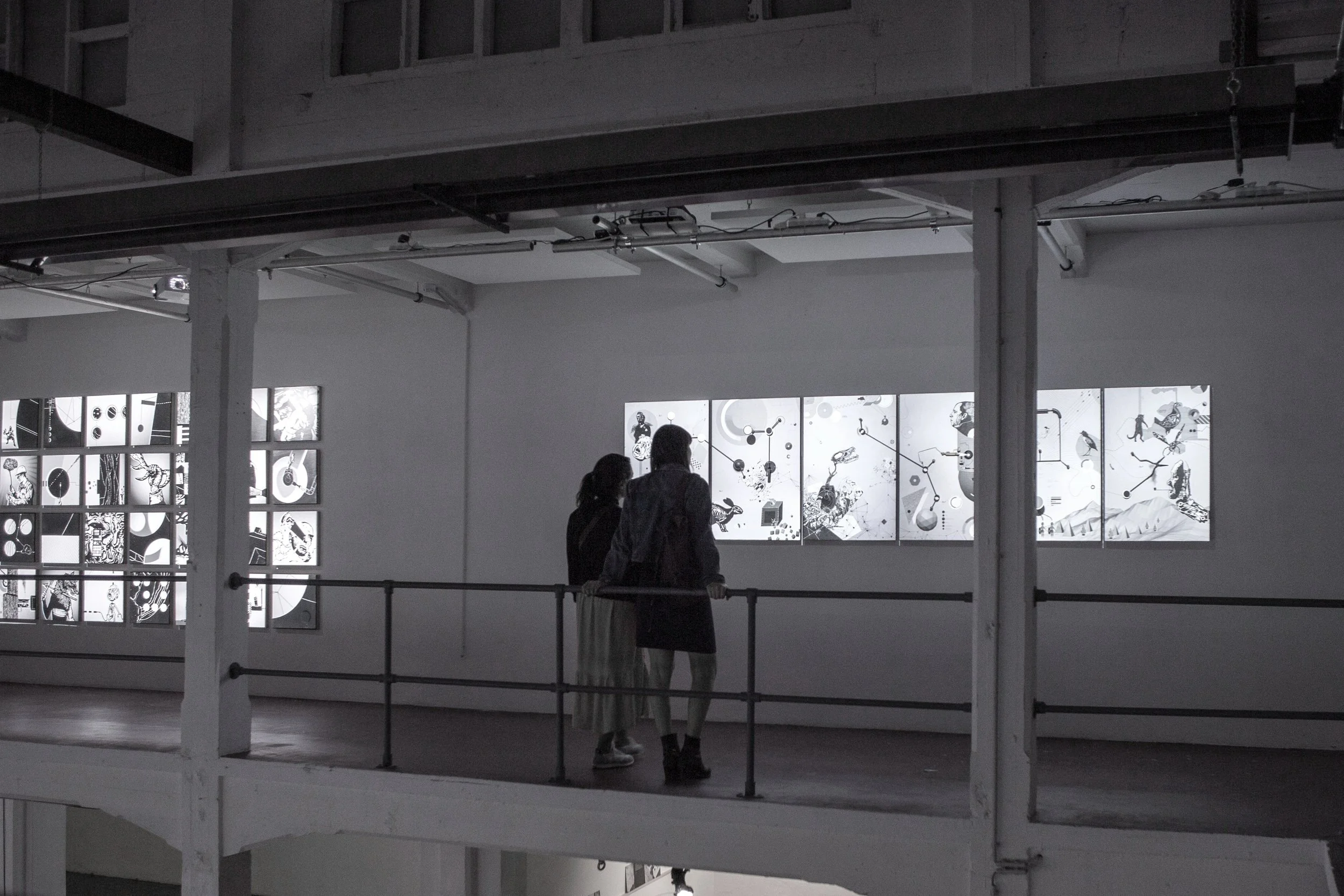 Exhibition view of Mécaniques Discursives at LaVallée Brussels with visitors observing wall installations