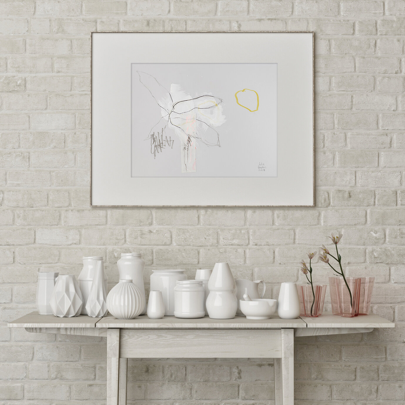 Minimal botanical artwork in a white interior with white pottery.