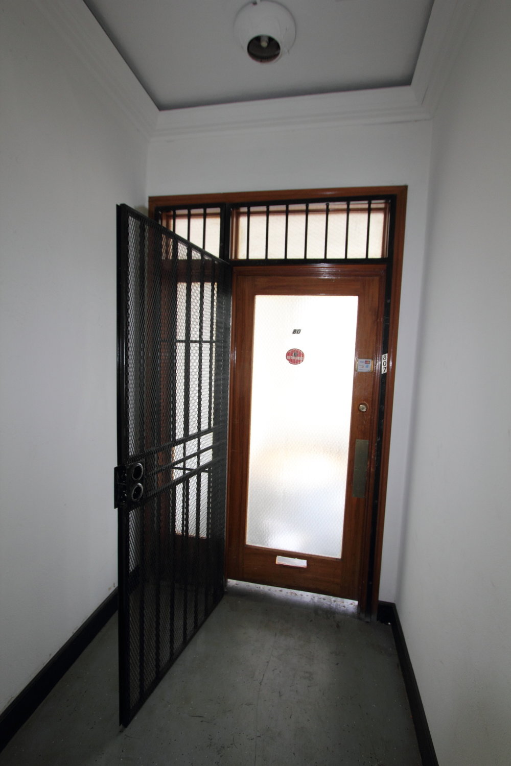 Original 1925 office door with transom, before rehabilitation.