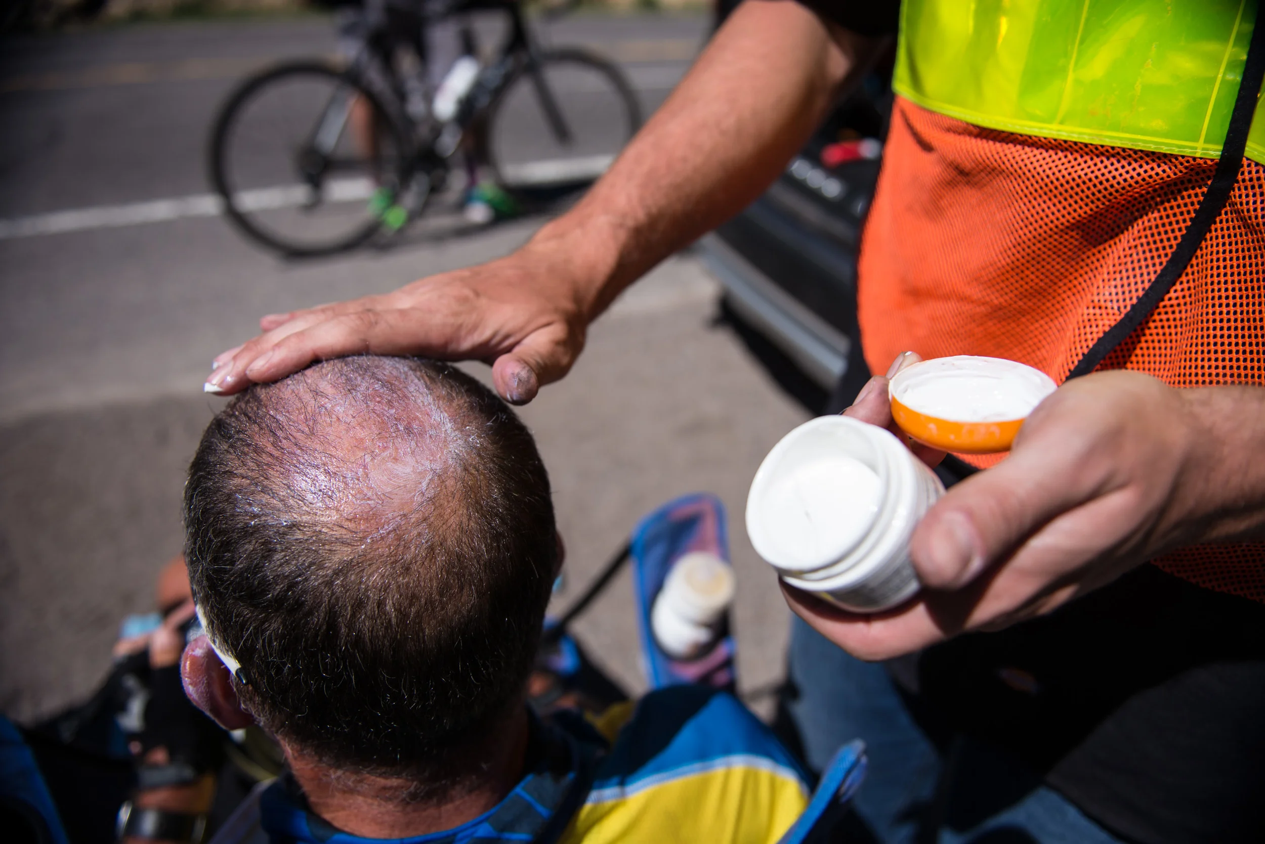 Crew member Tyler Jandreau applies zinc oxide cream to Marshall's head to prevent sunburns during the day ride on June 18th, 2016.