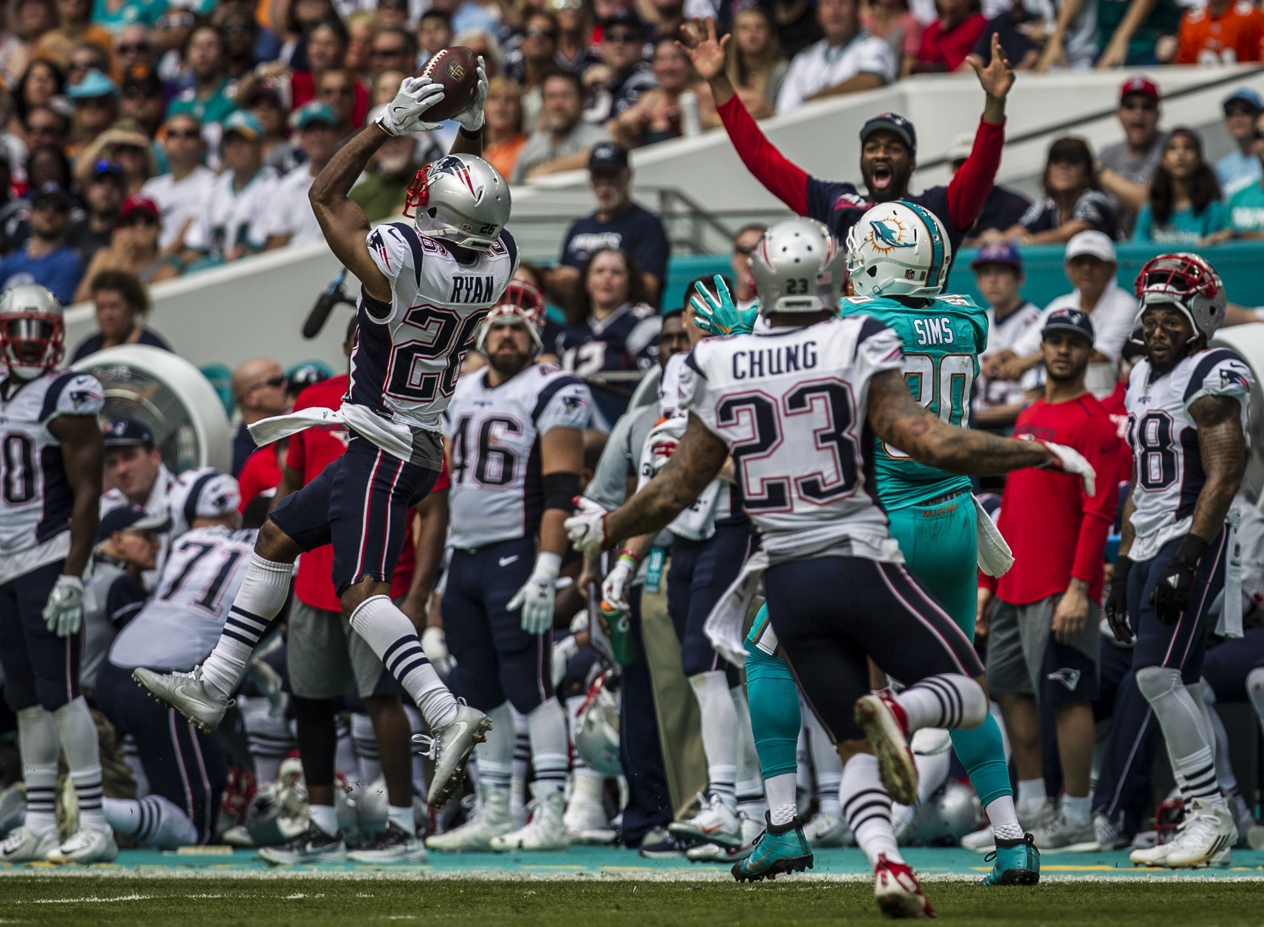  New England Patriots cornerback Logan Ryan (26) intercepts a pass intended for Miami Dolphins tight end Dion Sims (80) as the Patriots sideline celebrates at Hard Rock Stadium in Miami Gardens, Florida, January 1, 2017. 