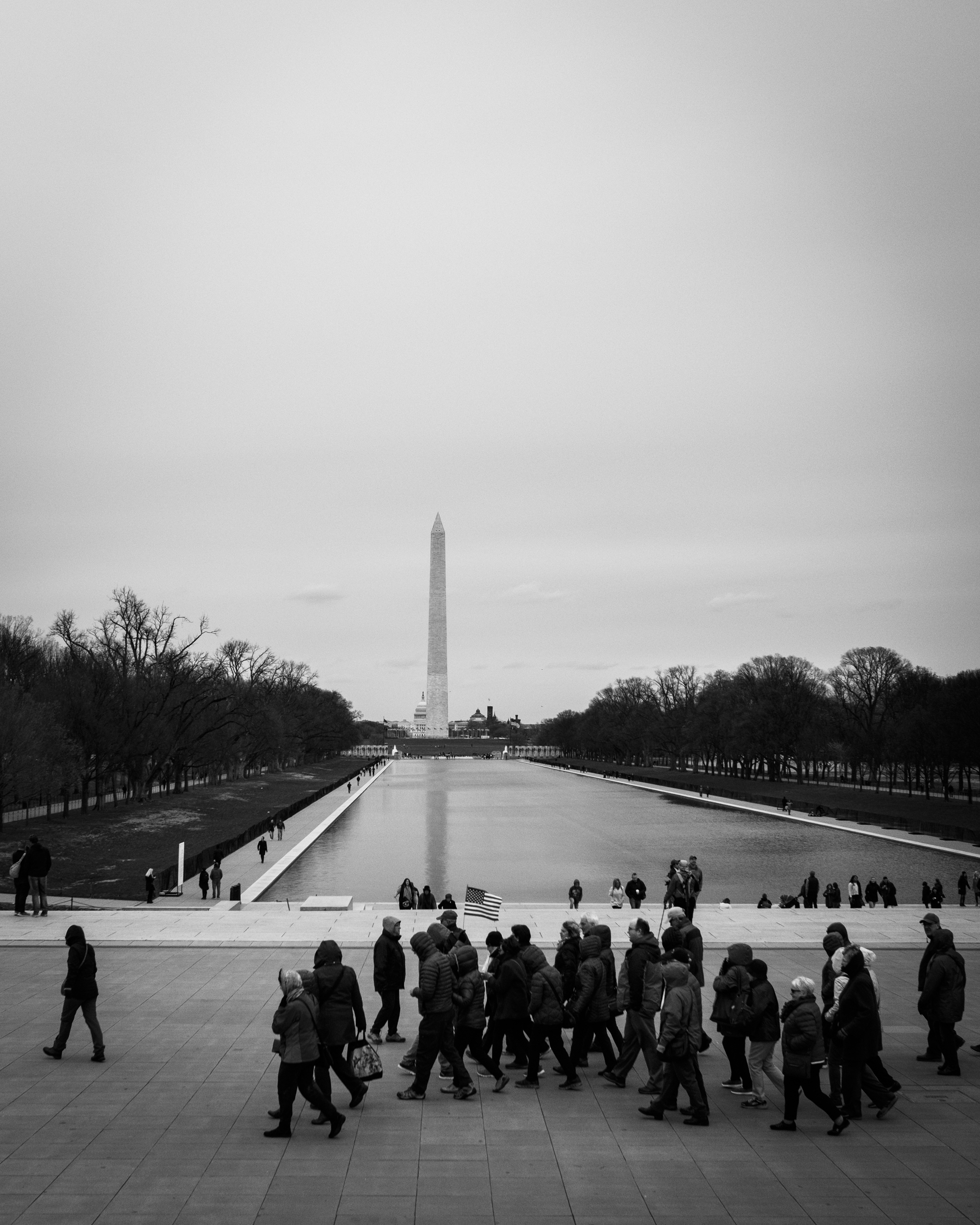  A group of tourists walks in front of the Lincoln Memorial Reflecting Pool. 