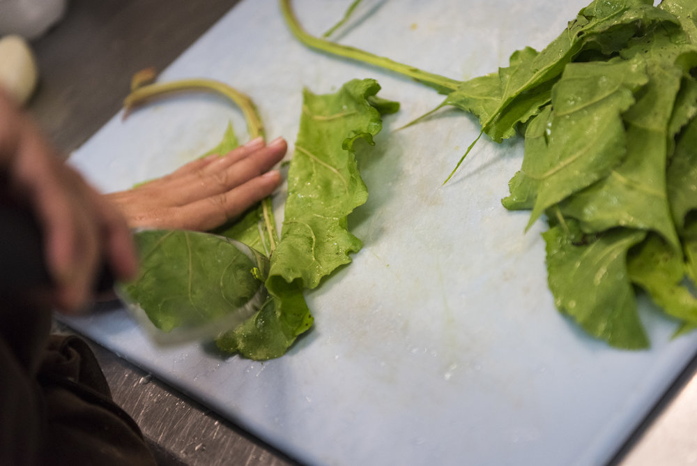  One of Roberto Matos's team members cuts lettuce in preparation for the dinner shift at COPA, Roberto's restaurant. Roberto strives to create the best working environment for his employees, who he refers to as team members. "I don't ever ask them to