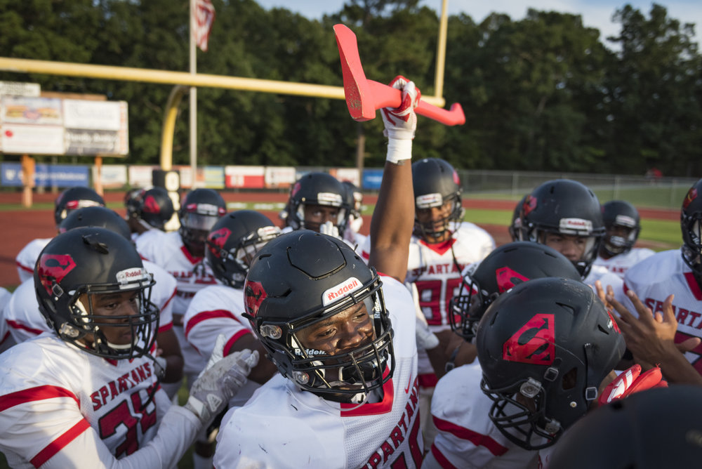  Southern Durham junior linebacker Jaki Brevard raises the team axe before the Spartan's game against Orange Highschool in Hillsborough, North Carolina. The team captain usually carries the axe before games. 