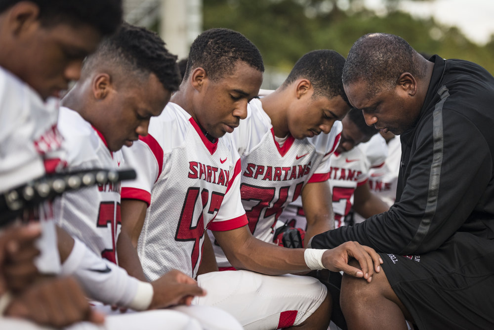 Southern Spartan head coach Darius Robinson prays with his players before the team's game against Cardinal Gibbons. During a pre-game pep talk with his players, Head Coach Robinson asked his players if they knew why they prayed... "We pray before ga