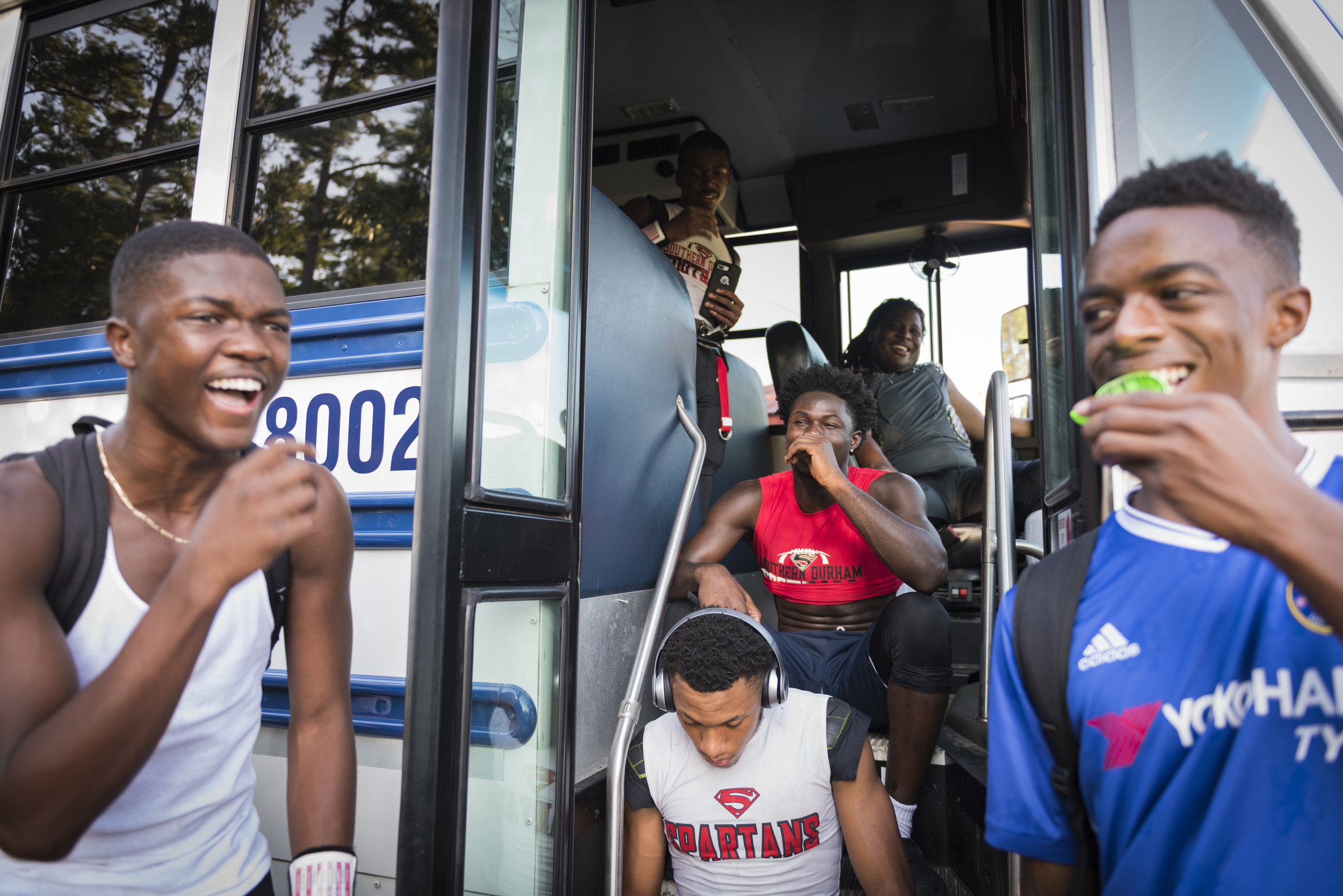  Southern Durham football players relax before an away game. The Spartans usually stayed on the team bus until they had to start warming up. Many schools in the area did not have visitor locker rooms. 