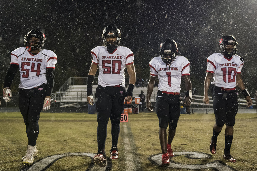  Southern Durham senior captains walk to the center of the field for the coin toss. The Spartans won their second-to-last game against East Chapel Hill, 42-7. 