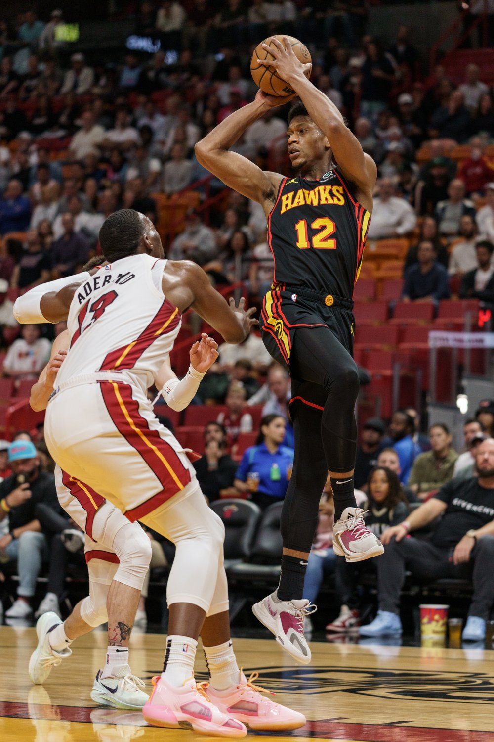  MIAMI, FL - APRIL 11: De'Andre Hunter #12 of the Atlanta Hawks passes the ball while being guarded by Bam Adebayo #13 of the Miami Heat at Kaseya Center on April 11, 2023 in Miami, Florida. 