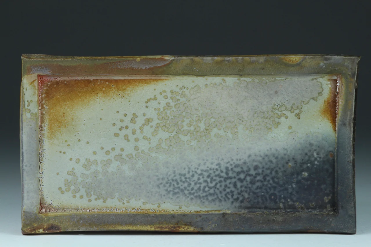 Cheese plate, 10" long, stoneware with flashing slip.