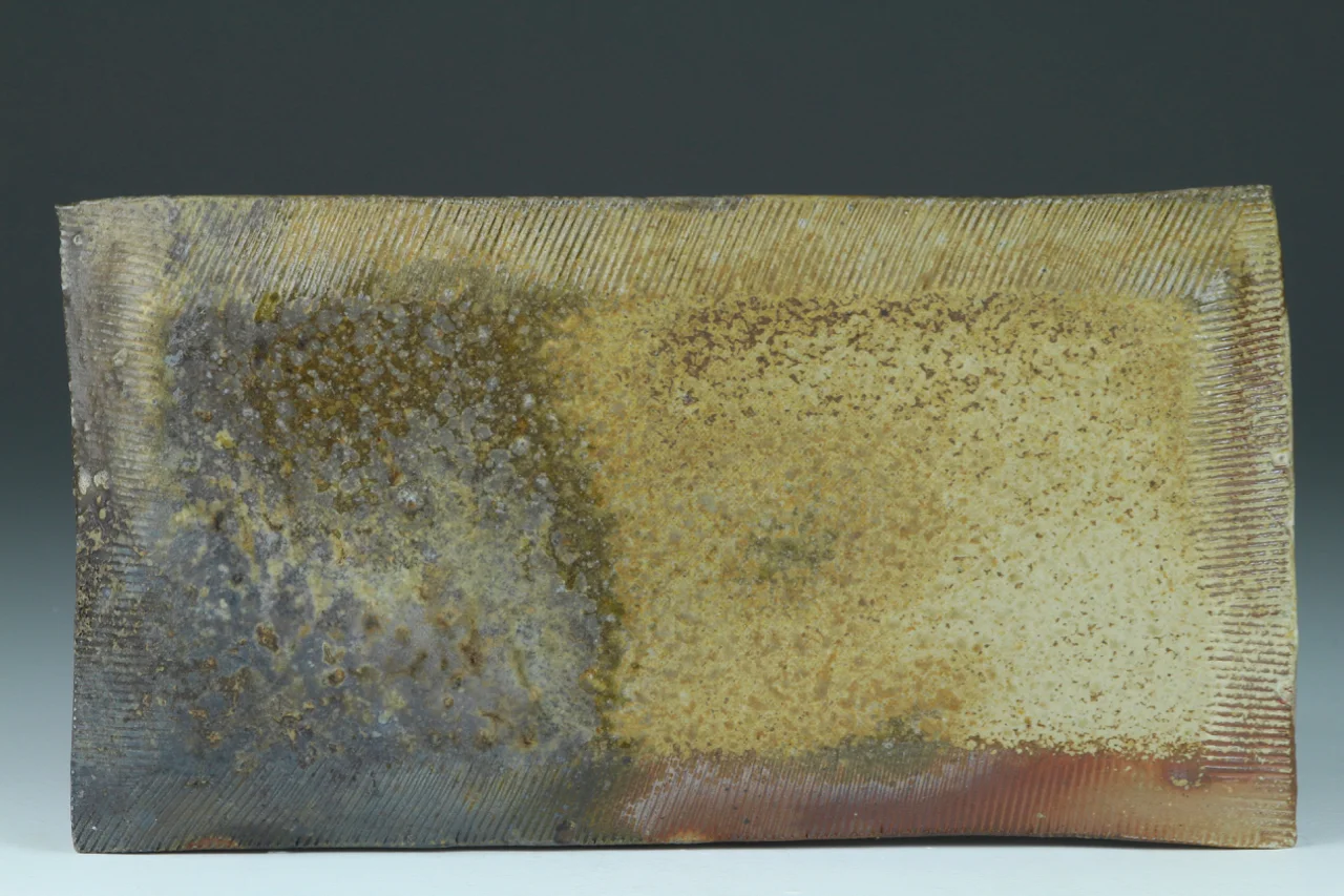 Cheese plate, 10" long, stoneware with flashing slip. Reverse View.
