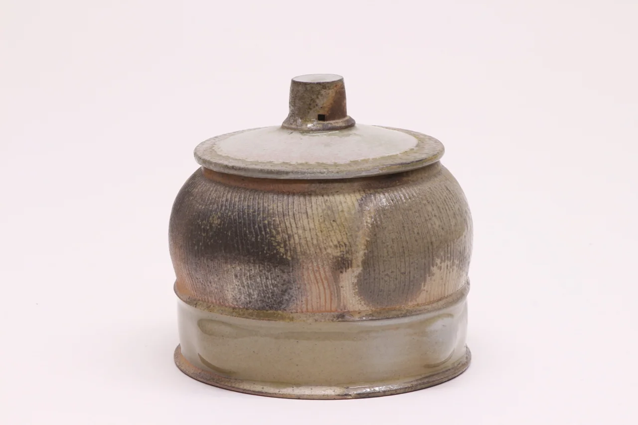 Covered jar, 6" high, glazed stoneware with flashing slip.