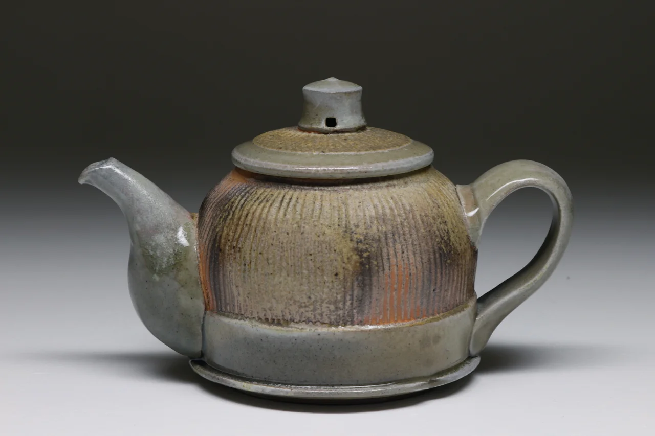 Teapot, 6" high, glazed stoneware with flashing slip.