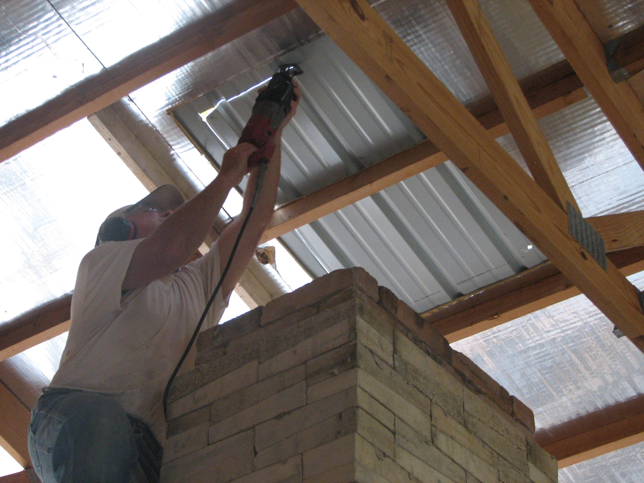  Cutting through the roof so the chimney can pass through. 