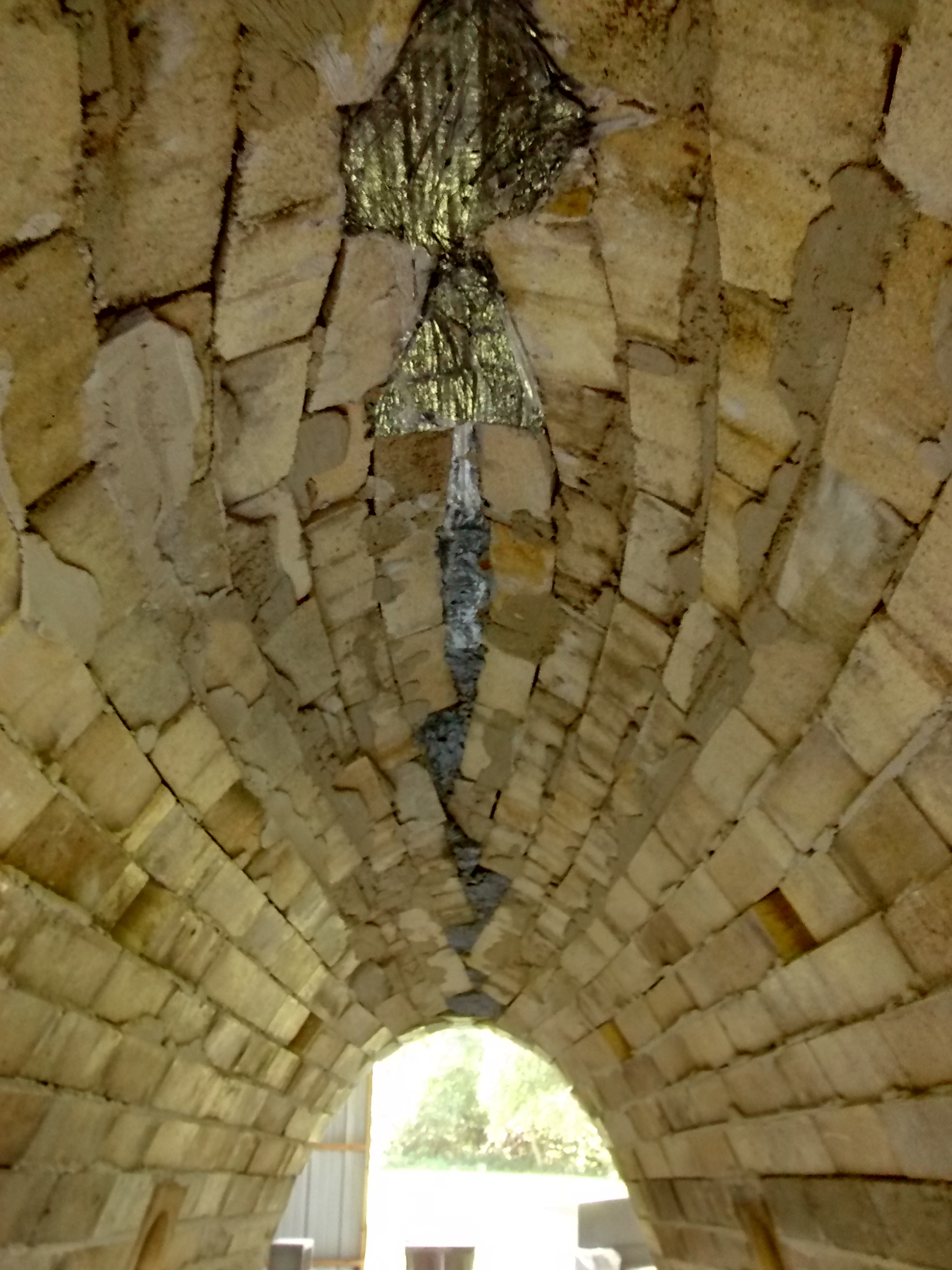 The crown of the first chamber, showing the castable (dark colored) and some excess mortar that will be scraped off.