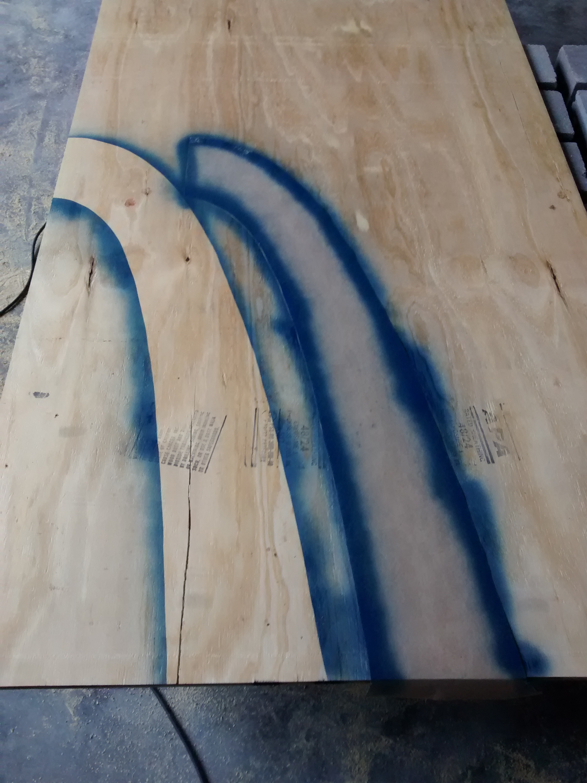 Spray paint traces the paper forms onto plywood to create arch ribs. If you make the ribs in halves, you can get a bunch on a sheet of plywood.
