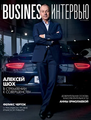 Cover of Business Interview magazine featuring a man in a suit standing in front of a luxury car in an office setting.