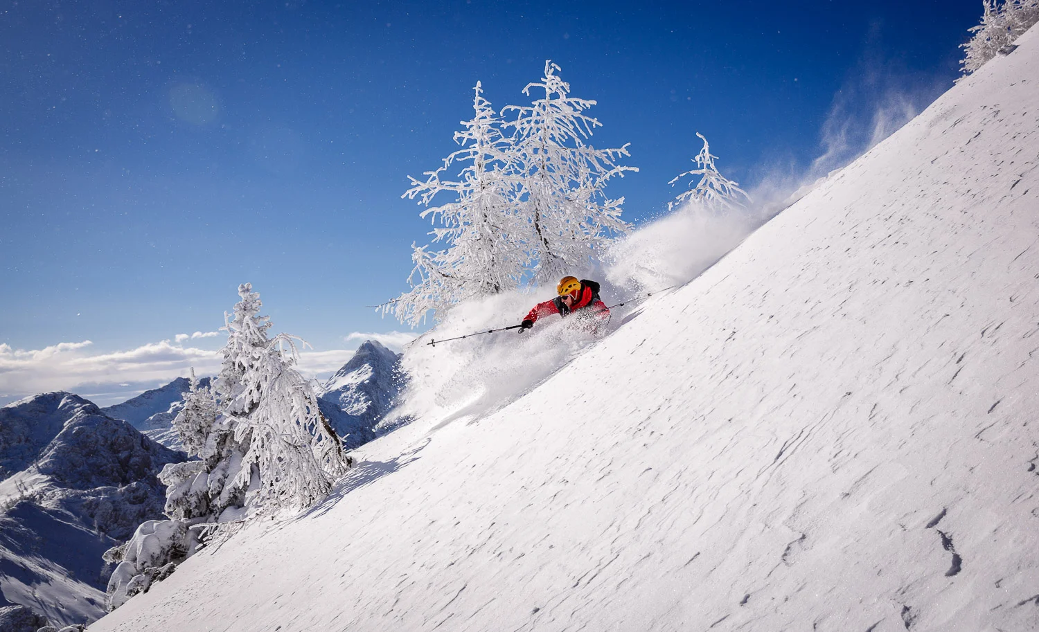 Marko backcountry skiing on a bluebird day in Julian Alps, Slovenia.