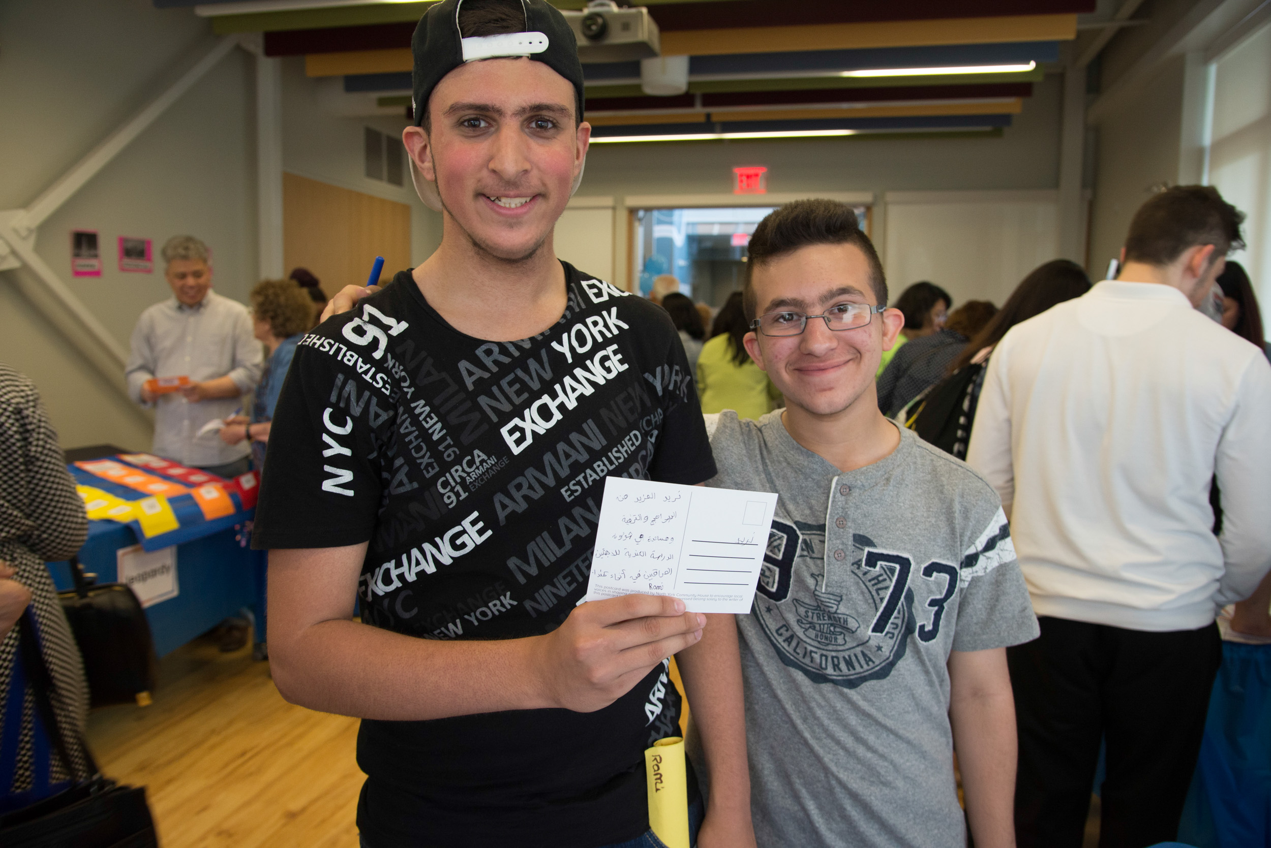 Two young participants show off a postcard to their elected official
